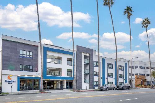 a row of buildings on a street with palm trees at Comfort Inn Santa Monica - West Los Angeles in Los Angeles