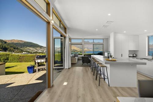 a kitchen and living room with a view of the mountains at Whakata on Whitbourn - Luxury Retreat With Spa in Queenstown