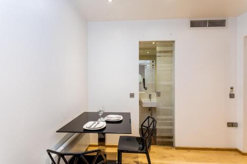 une salle à manger avec une table et des chaises noires dans l'établissement Space ApartHotel, à Londres