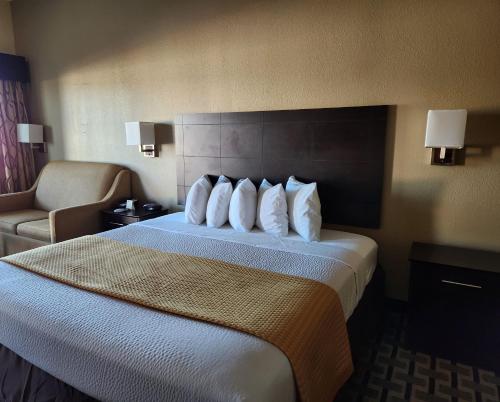 a hotel room with a bed and a chair at Days Inn by Wyndham Baytown East in Baytown