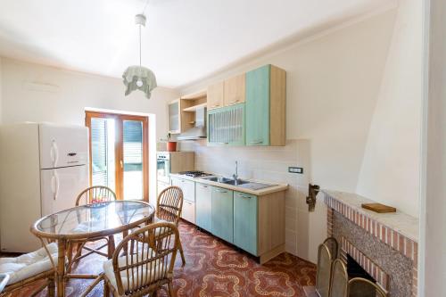 cocina con mesa, sillas y nevera en Casa Fiorella - Irpinia en Lioni