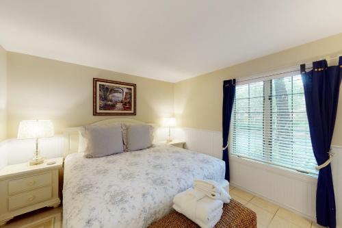 um quarto com uma cama grande e uma janela em 4250 Mariner's Watch Villa em Kiawah Island
