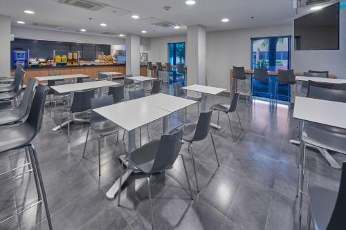 a dining room with tables and chairs in a cafeteria at City Express by Marriott Tijuana Rio in Tijuana