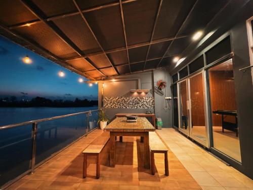 un balcón con una mesa de madera y un banco en un barco en Canoe and Fishing , Free Pickup en Batam Centre