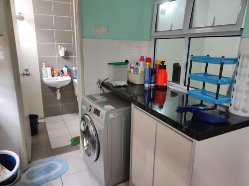 a kitchen with a washing machine and a sink at Layyin's Damai Residences in Shah Alam