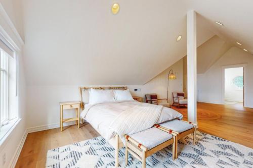 a white bedroom with a bed and a rug at Whidbey Wonder in Clinton