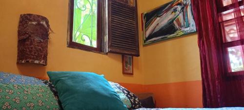 a living room with a couch and two windows at Vila Santa Rosa Guest House in Ilhabela