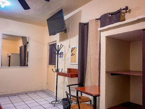 um quarto com uma mesa e uma televisão na parede em Hotel Buenos Aires em Durango