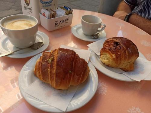 a table with two plates of pastries and a cup of coffee at Antica Residenza Dell'Angelo in Lucca