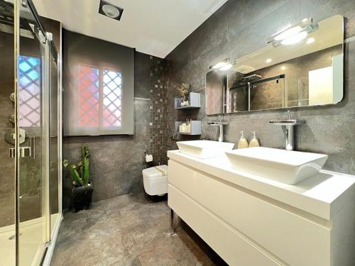 a bathroom with two sinks and a shower at Rooftop Pool with Views in Motril