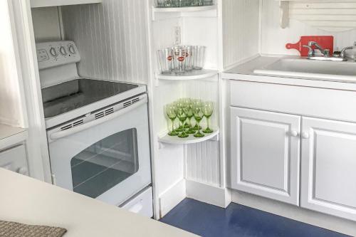 una cocina con armarios blancos y un horno de fogón blanco en Cherry Grove Enchantment, en Cherry Grove