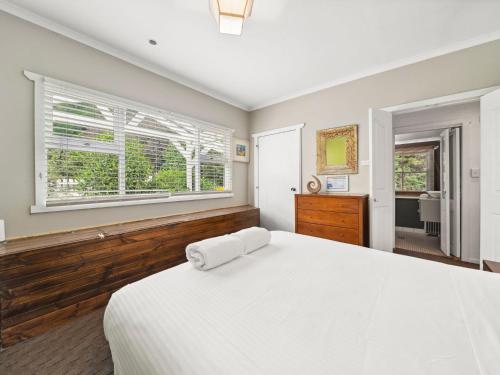 布雷克希斯的住宿－藍色中度假屋，卧室设有一张白色大床和一扇窗户。