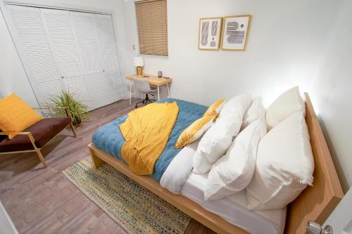 a bedroom with a bed with pillows and a table at [1] Chic & Cozy Retreat Walk to KU/Mass/Dining! in Lawrence