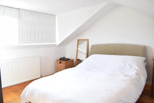 a bedroom with a white bed and a mirror at Contemporary 2BD Flat 4 Mins to Finsbury Park! in London