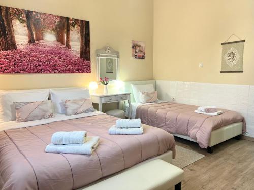 two beds in a room with a painting on the wall at Amethyst, luxury house nearby Delphi in Kírra