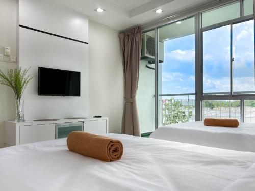 - une chambre avec 2 lits et une grande fenêtre dans l'établissement Modern Muji Home Retreat near Taiping Lake Garden with Free Netflix, à Taiping