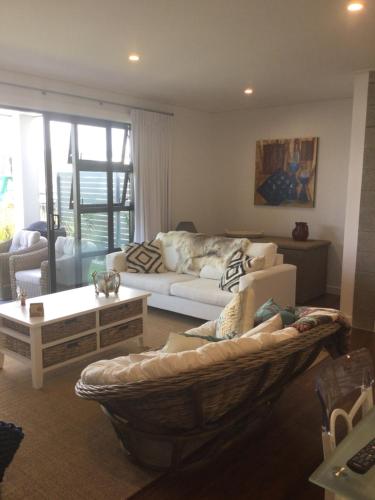 a living room with a couch and a table at Tairua Marina Villa in Tairua