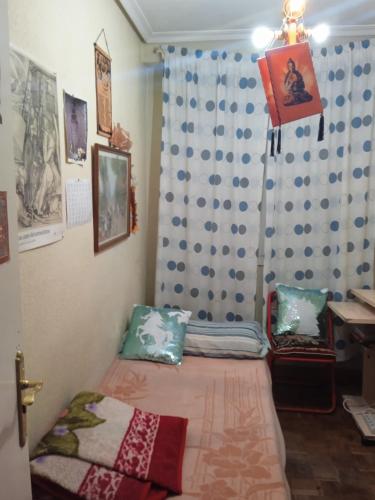 1 dormitorio con cama, cortina y escritorio en Habitación acogedora por días, en Madrid