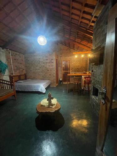 Zimmer mit einem Bett und einem Tisch in der Unterkunft Chalé no sítio. in Cacimba de Dentro