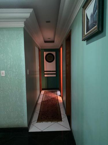 um corredor com paredes verdes e um tapete no chão em Casa de ferias em Vitória