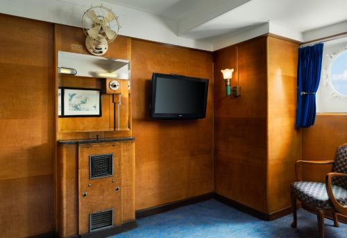 a room with a flat screen tv on a wall at The Queen Mary in Long Beach