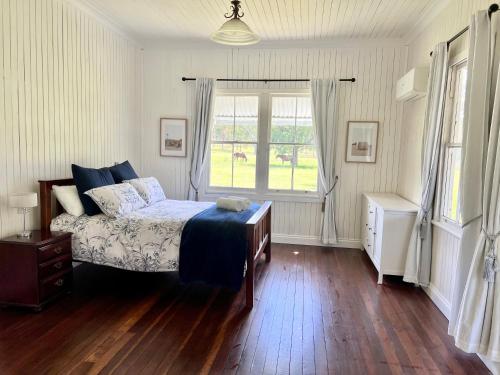 a bedroom with a bed and a window at The Cottage Farm Stay - Grandchester in Grandchester
