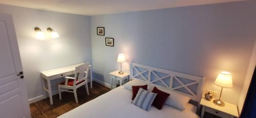 - une chambre avec un lit, un bureau et deux lampes dans l'établissement À mi-chemin, à Marcillac-Vallon