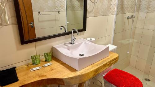 a bathroom with a white sink and a shower at Pousada Casa Redonda in Campos do Jordão