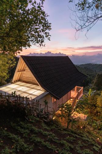 a house with a black roof on top of a hill at Garden Terrace Bali in Gobleg