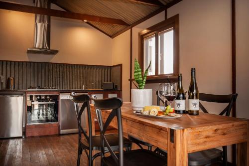 a kitchen with a wooden table with wine bottles at Angaston Saleyards Luxury Accommodation in Angaston