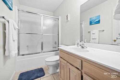 a bathroom with a sink and a toilet and a shower at Blue Door Cottage at Scotsdale in Bella Vista