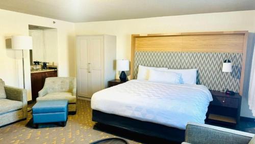 um quarto de hotel com uma cama e uma cadeira em Gateway Hotel & Convention Center Grand Blanc Flint Airport Michigan em Flint