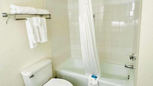 y baño con aseo blanco y ducha. en Gateway Hotel & Convention Center Grand Blanc Flint Airport Michigan, en Flint