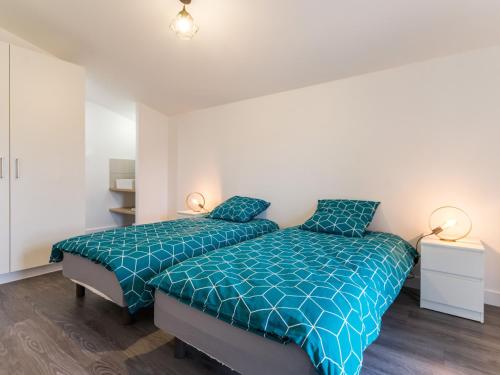 a bedroom with two beds with blue comforter at Gîte Clisson, 4 pièces, 6 personnes - FR-1-306-1208 in Clisson