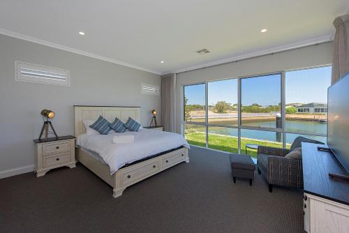 a bedroom with a bed and a large window at A Waterside Paradise - Geographe's Hidden Oasis in Geographe