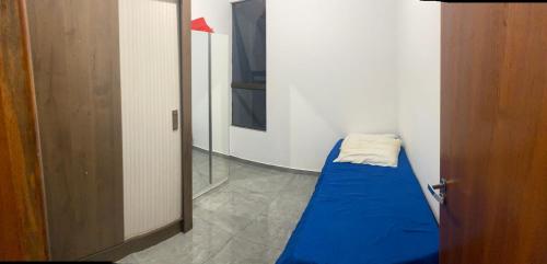 Habitación pequeña con cama azul y espejo. en Casa - Temporada Show rural, en Cascavel