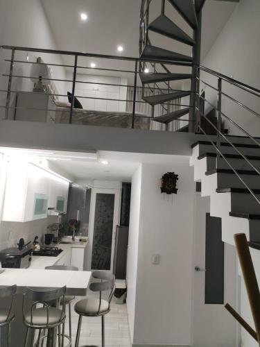 una cocina y comedor con una escalera en una casa en Casa de Maria, en Miraflores