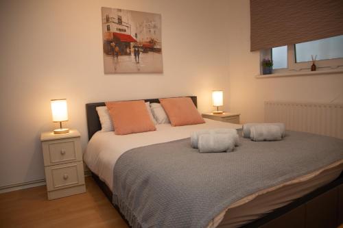 a bedroom with a large bed with two lamps at Large and bright one bedroom apartment with free parking! in London