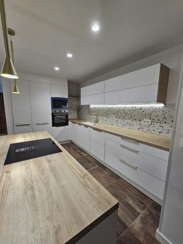 una cucina con armadi bianchi e ripiano in legno di Apartamento Figueres Plaza Cataluña a Figueres
