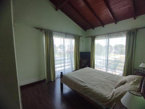 1 dormitorio con 1 cama y 2 ventanas grandes en Mar celeste en Mar del Plata