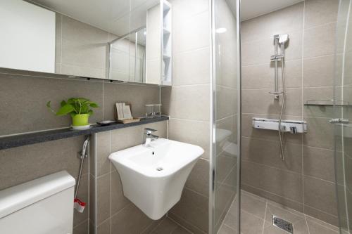 a bathroom with a sink and a glass shower at Surf Resort JD Yangyang in Yangyang