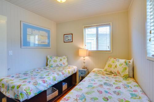 1 dormitorio con 2 camas y ventana en Historic Nautical Retreat Steps From Beach and Bites, en Avalon