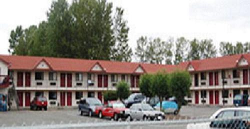 a large building with cars parked in a parking lot at Sunshine Motel in Fife