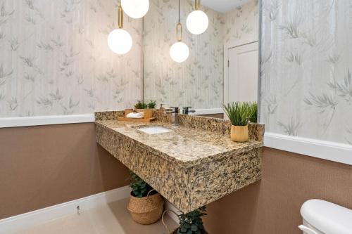 a bathroom with a large marble sink and a mirror at 4 Bedroom- 4,5 Bathroom Magic Village 7603 Rd in Orlando