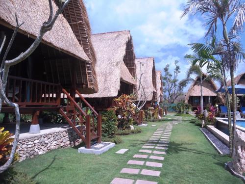 a row of cottages with a walkway in front at Harta Lembongan Villas in Nusa Lembongan