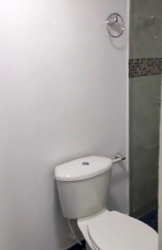 a white bathroom with a toilet and a shower at Sharick Beach House in Tubará