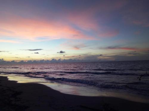 a sunset on the beach with the ocean at Sharick Beach House in Tubará
