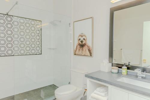 ein Badezimmer mit einem WC, einem Waschbecken und einem Spiegel in der Unterkunft The Hive Adjacent 1st Floor 101 pet 102 balcony Pet in Wilmington