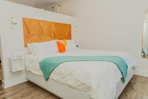 ein weißes Bett mit bunten Kissen im Schlafzimmer in der Unterkunft The Hive Adjacent 1st Floor 101 pet 102 balcony Pet in Wilmington