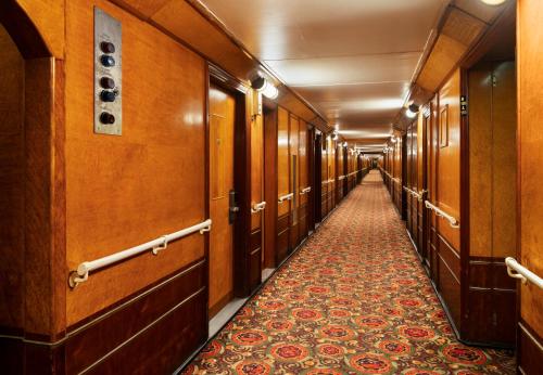 un couloir vide d'un bâtiment avec des murs en bois et un tapis dans l'établissement The Queen Mary, à Long Beach